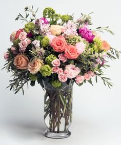 a vase filled with lots of different colored flowers