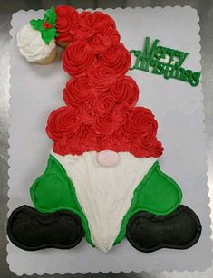 a cupcake shaped like santa clause on top of a sheet cake