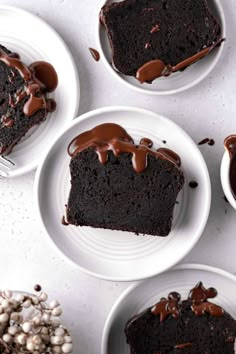 four plates with slices of chocolate cake on them