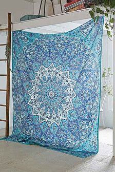 a large blue and white quilt hanging from a ladder in front of a planter