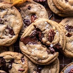 chocolate chip cookies and pecans on a cooling rack next to a glass of beer