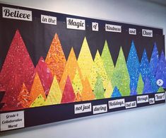 a bulletin board with different colored paper trees on it's sides and the words believe in the middle