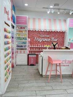 the interior of a store with pink and white decor on the walls, two stools in front of an ice cream shop counter