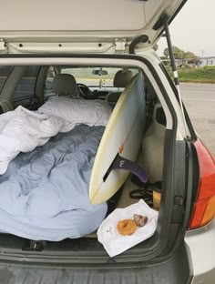 a surfboard is sitting in the back of a car with its bed pulled up