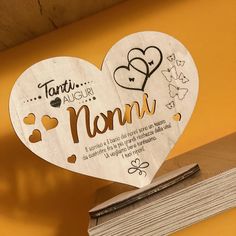 two heart shaped wooden plaques with names and hearts on them, hanging from a shelf