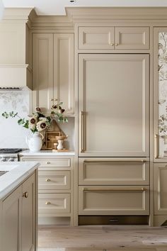 a kitchen with beige cabinets and white counter tops