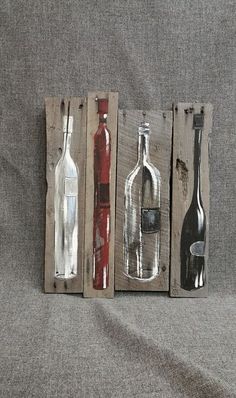 three bottles and two spoons are sitting on a gray surface next to each other