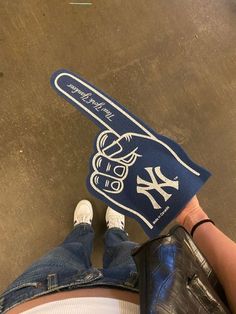 someone is holding up a new york yankees baseball bat shaped rug on the floor in front of their feet