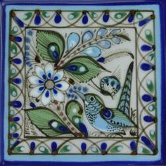 a blue and green tile with two birds on it's side, surrounded by flowers