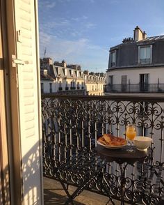 breakfast is served on the balcony of an apartment building in paris, overlooking the eiffel tower