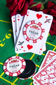 playing cards and casino chips on a green tablecloth with red roses in the background