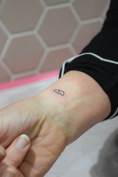 a woman's arm with a small tattoo on her left wrist and the word go written in black ink