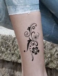 a woman's foot with a flower tattoo on the side of her calf leg