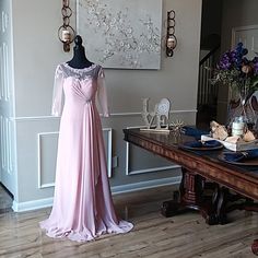 a dress is displayed on a mannequin next to a table