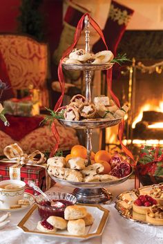 three tiered trays filled with pastries and fruit on top of a table