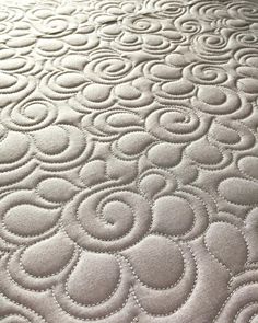 an image of a close up view of a bed with circles on the coverlet