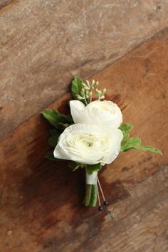 a bouquet of white flowers sitting on top of a wooden table