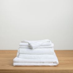 a stack of white towels on top of a wooden table