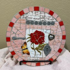 a mosaic plate with roses and butterflies on it