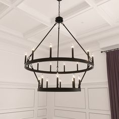 a chandelier hanging from the ceiling in a room with white walls and purple curtains