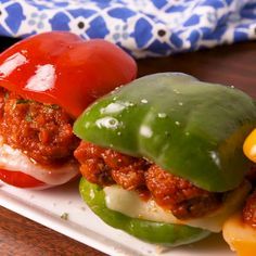 two stuffed peppers sitting on top of a white plate