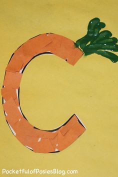 the letter c is made out of construction paper and cut into carrots with green leaves