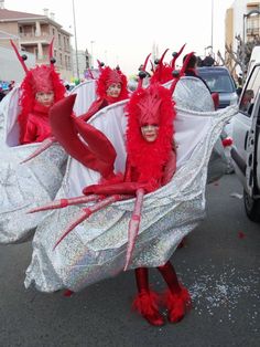 two women in red and white costumes walking down the street