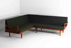 a green couch sitting on top of a white floor next to a wooden frame chair