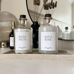 two bath salts sitting on top of a counter