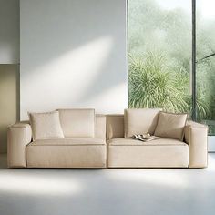 a white couch sitting in front of a window