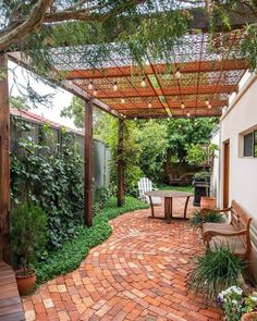 an outdoor patio with brick pavers flooring and pergolated roof over it