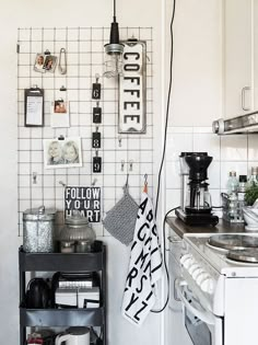 a kitchen area with a stove, coffee maker and various items hanging on the wall