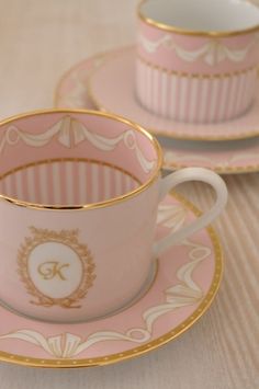 two pink cups and saucers with gold trim