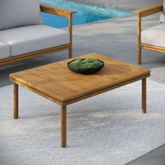 a wooden table sitting on top of a rug next to a couch and coffee table