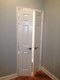 an empty room with two white doors in it