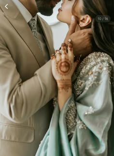 a man and woman kissing each other with their hands painted on the forehead, in front of a white background