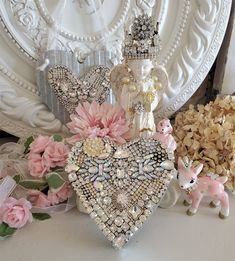 there is a heart shaped decoration on the table with flowers and other decorations around it