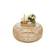 a wicker basket with flowers and wine on it is sitting on a white surface