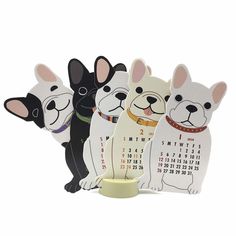 three dogs are standing next to each other in front of a calendar on a stand