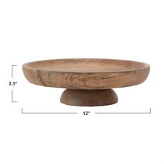 a wooden bowl sitting on top of a white table next to a measuring line with the measurements