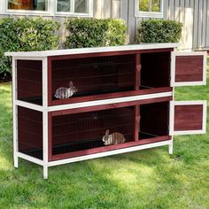 two cats are sitting in their cages on the side of a wooden cabinet outside