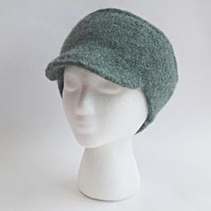 a white mannequin head wearing a green hat