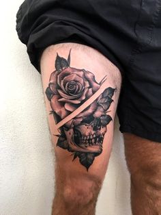 a man's leg with a tattoo on it and a rose in the middle