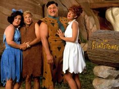 three people dressed as flintstones posing for a photo