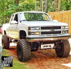 a white truck parked in front of a wooden fence