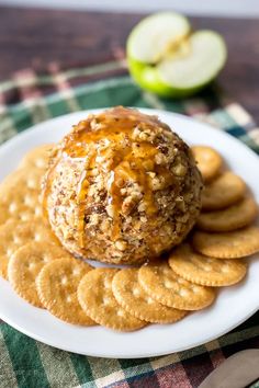 a cheese ball sitting on top of crackers next to an apple