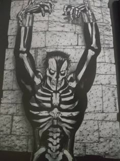 a skeleton with arms and legs stretched out in front of a brick wall, holding two hands above his head