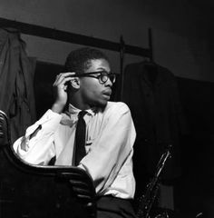 a black and white photo of a man in a tie talking on a cell phone