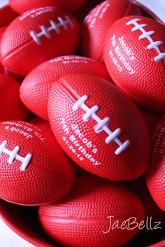 red footballs with white stitching in a bowl