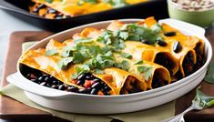 two white dishes filled with black beans and quesadillas on top of a wooden cutting board